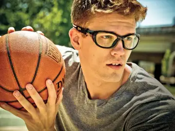 Man waring sports eye protection holding a basketball
